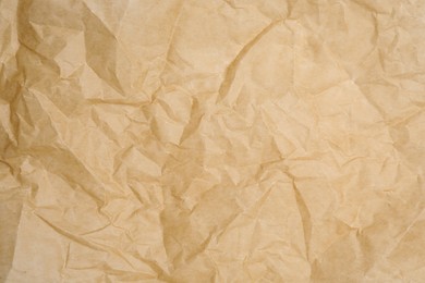 Texture of crumpled brown baking paper as background, closeup