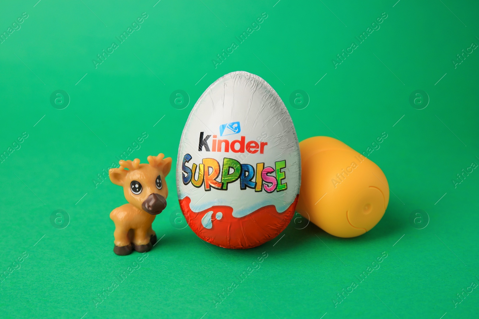 Photo of Slynchev Bryag, Bulgaria - May 25, 2023: Kinder Surprise Egg, plastic capsule and toy deer on green background