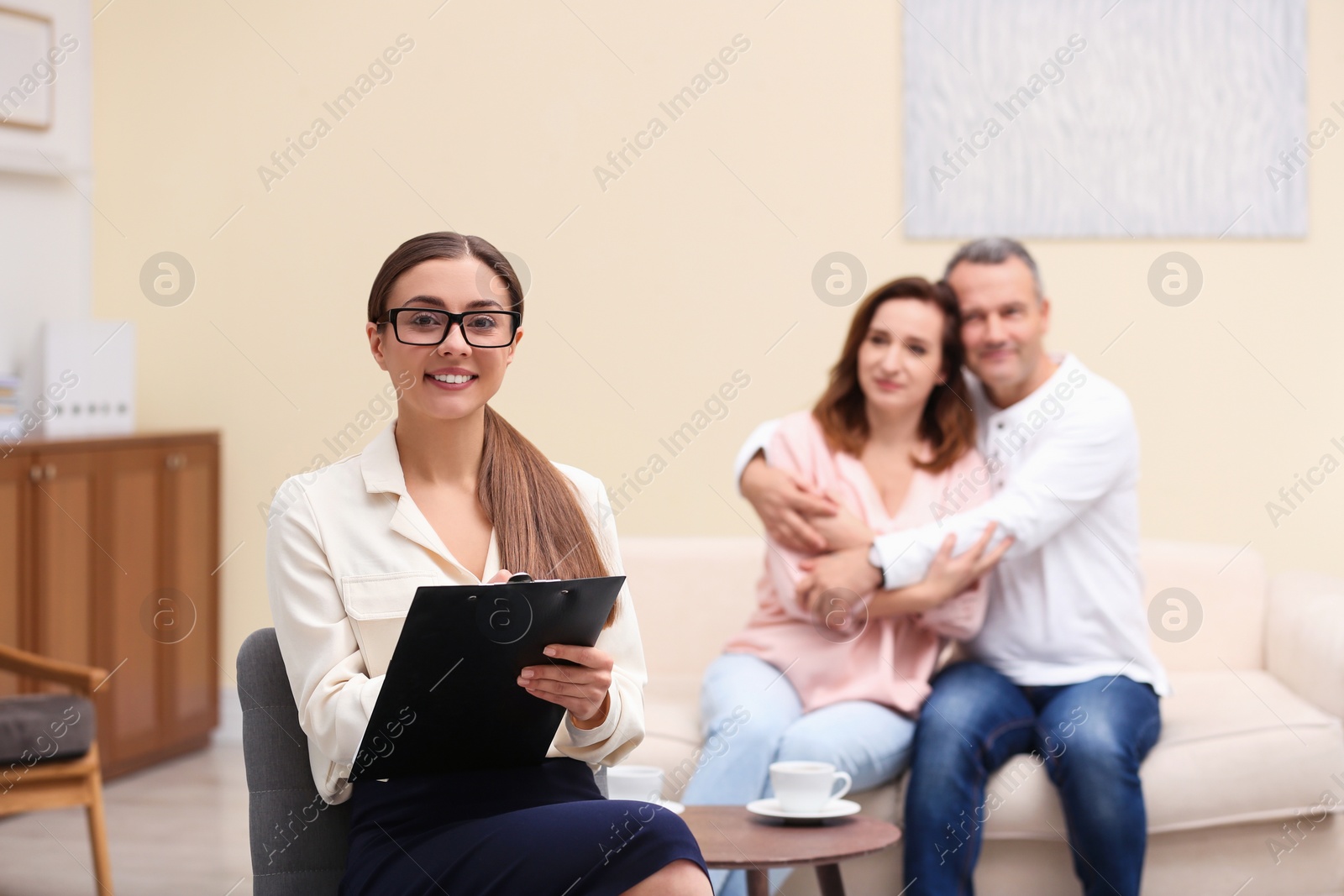 Photo of Psychotherapist and happy couple having meeting in office. Family counselling