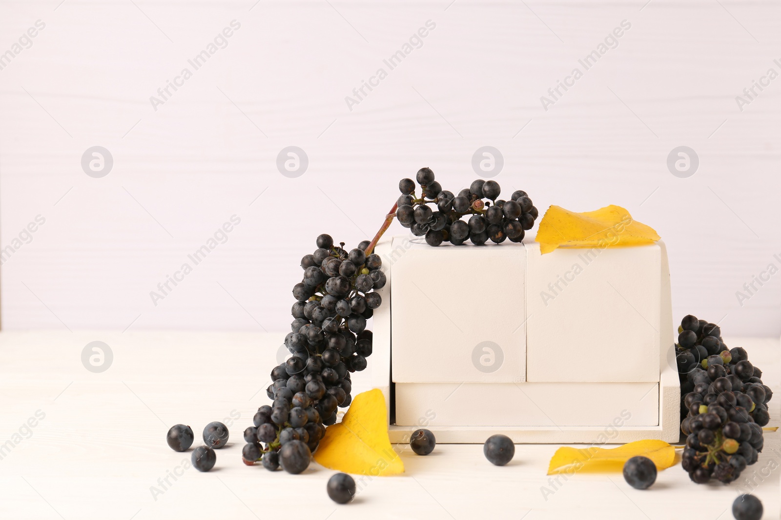 Photo of Thanksgiving day, holiday celebrated every fourth Thursday in November. Block calendar, yellow leaves and berries on white wooden table, space for text