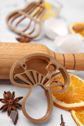 Photo of Cookie cutters and rolling pin on white table, closeup