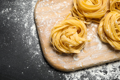 Photo of Tagliatelle pasta on wooden board, above view