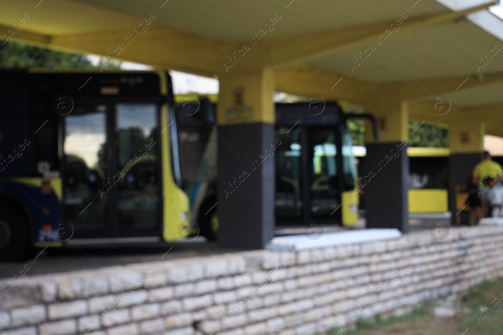 Photo of Blurred view of bus station with parked buses