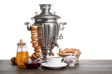 Samovar with hot tea, jam and delicious ring shaped Sushki (dry bagels) on table against white background