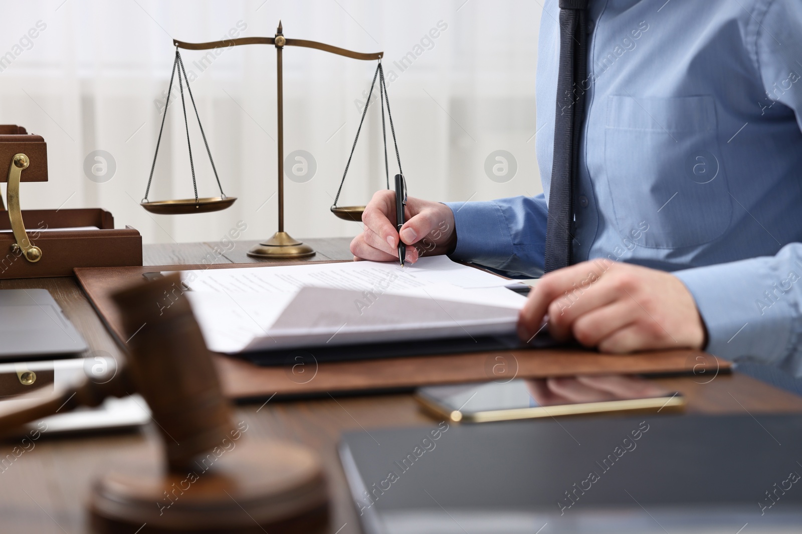 Photo of Lawyer working with documents at table indoors, closeup