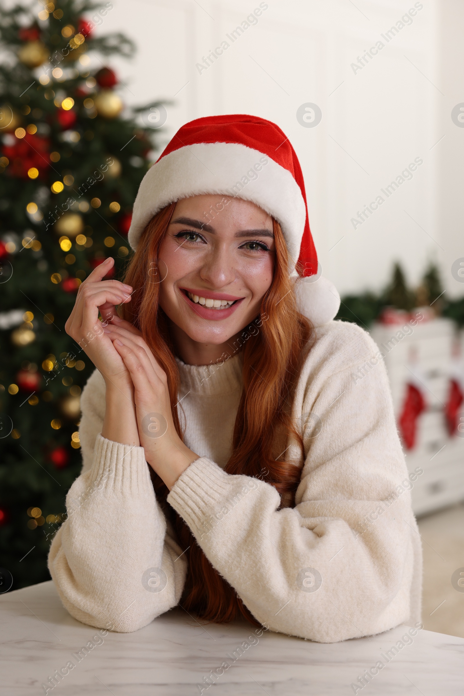 Photo of Beautiful young woman in Santa hat at home. Christmas celebration