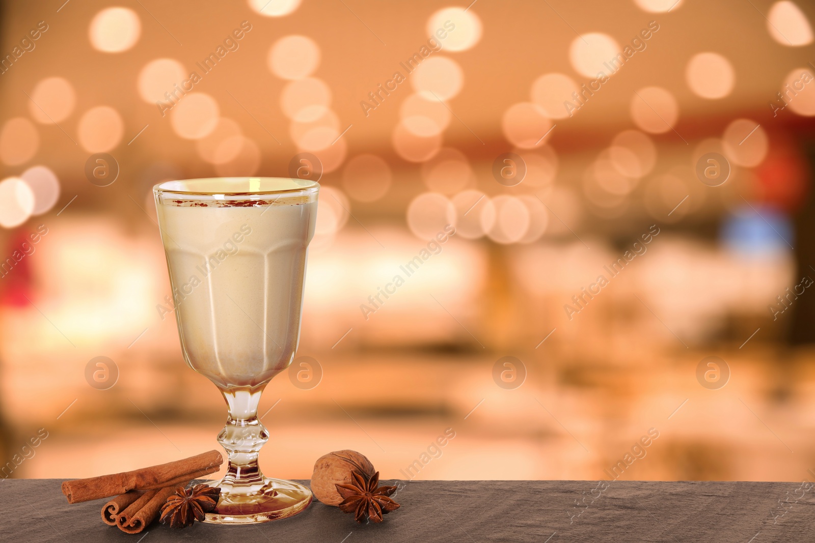 Image of Glass of delicious eggnog on table in bar, space for text