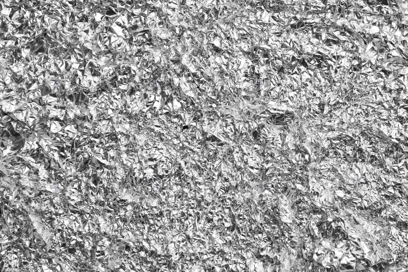 Photo of Crumpled silver foil as background, closeup view