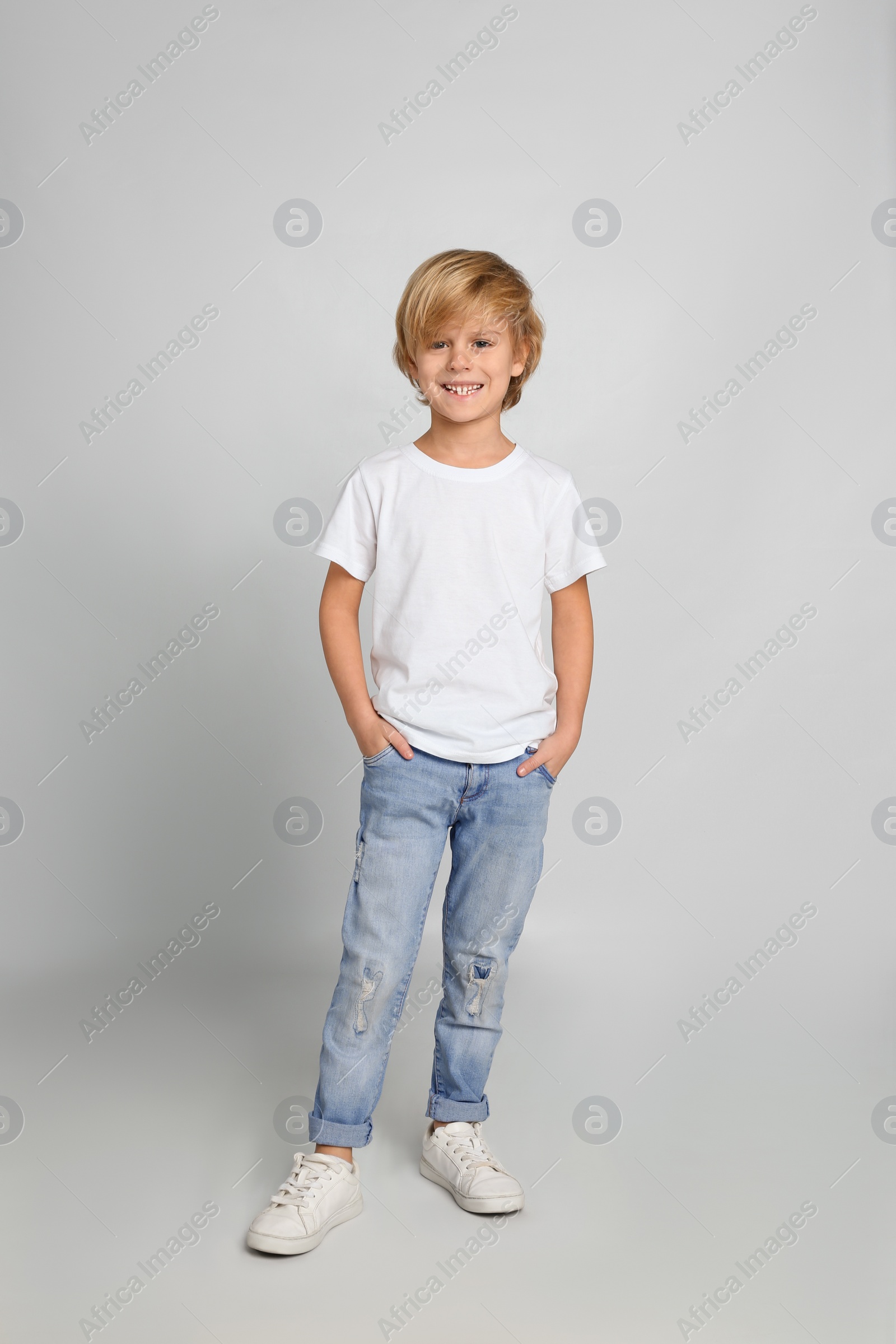 Photo of Cute little boy in casual outfit on light grey background