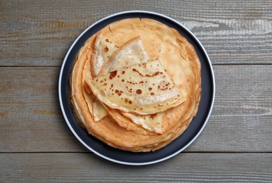 Stack of delicious crepes on grey wooden table, top view