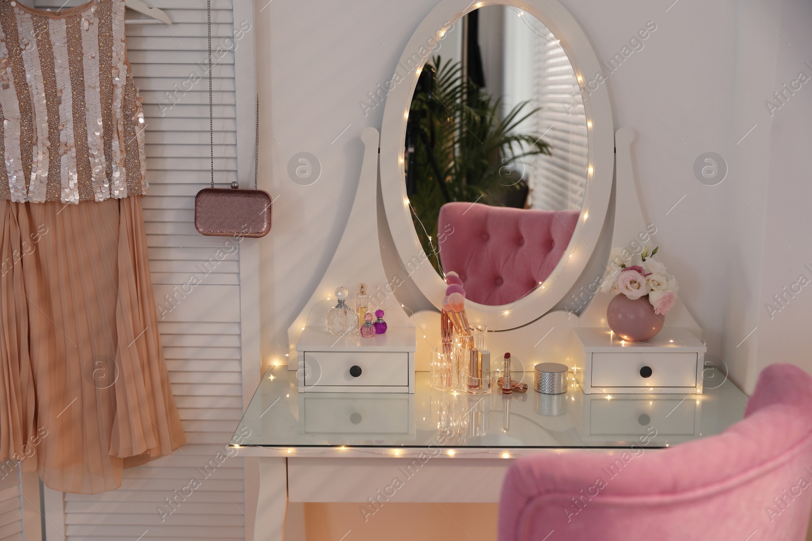 Photo of Elegant dressing table with lights and pink chair in stylish room interior