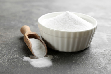 Photo of Baking soda in bowl on grey table