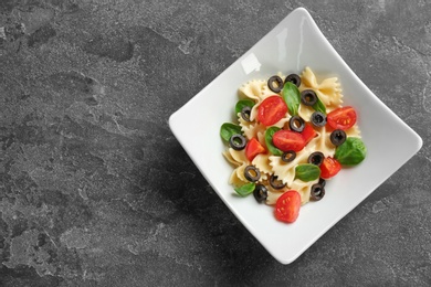 Plate with delicious pasta primavera on grey background, top view