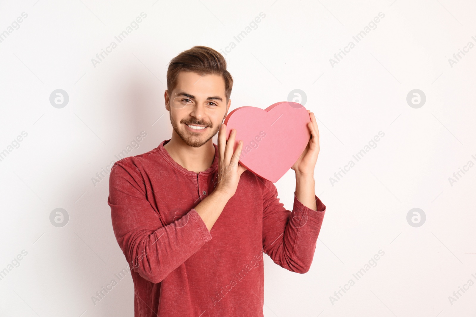 Photo of Portrait of young man with decorative heart on white background