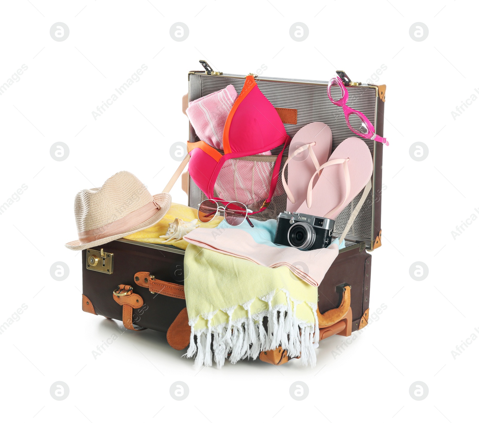 Photo of Open vintage suitcase with different beach objects packed for summer vacation isolated on white