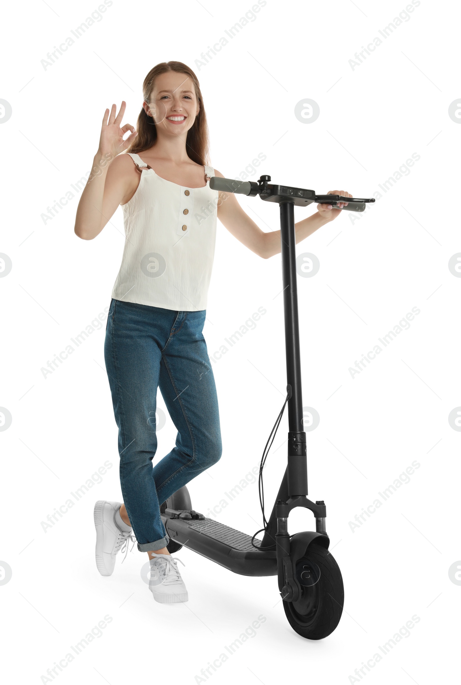 Photo of Happy woman with modern electric kick scooter showing OK gesture on white background