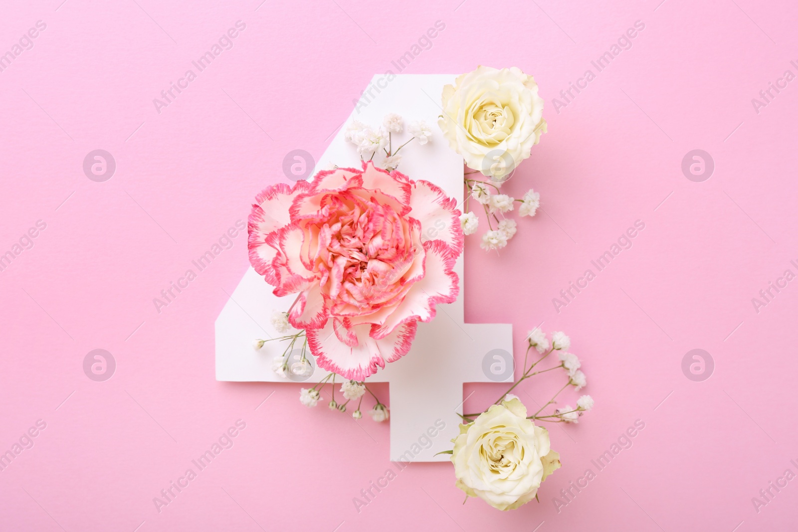 Photo of Paper number 4 and beautiful flowers on pink background, flat lay