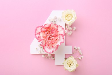 Photo of Paper number 4 and beautiful flowers on pink background, flat lay