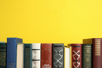 Photo of Collection of old books on yellow background, space for text