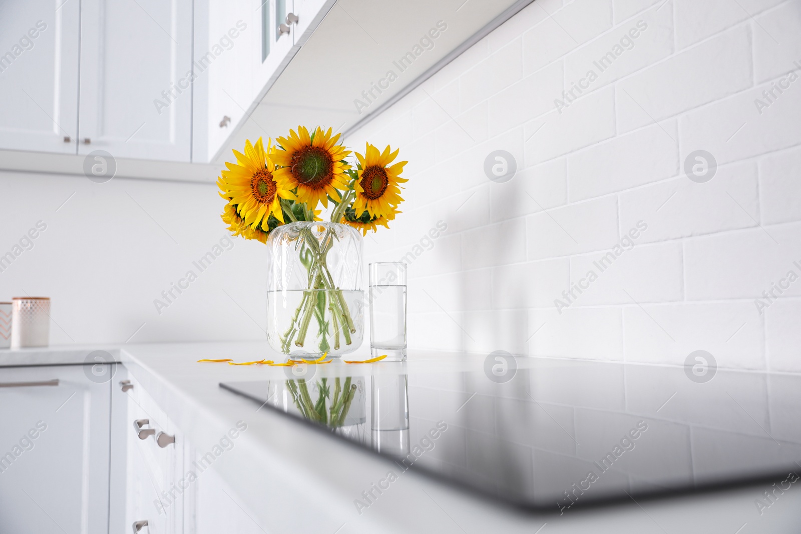 Photo of Bouquet of beautiful sunflowers on counter in kitchen. Space for text