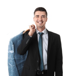 Photo of Young businessman holding hanger with jacket in plastic bag on white background. Dry-cleaning service