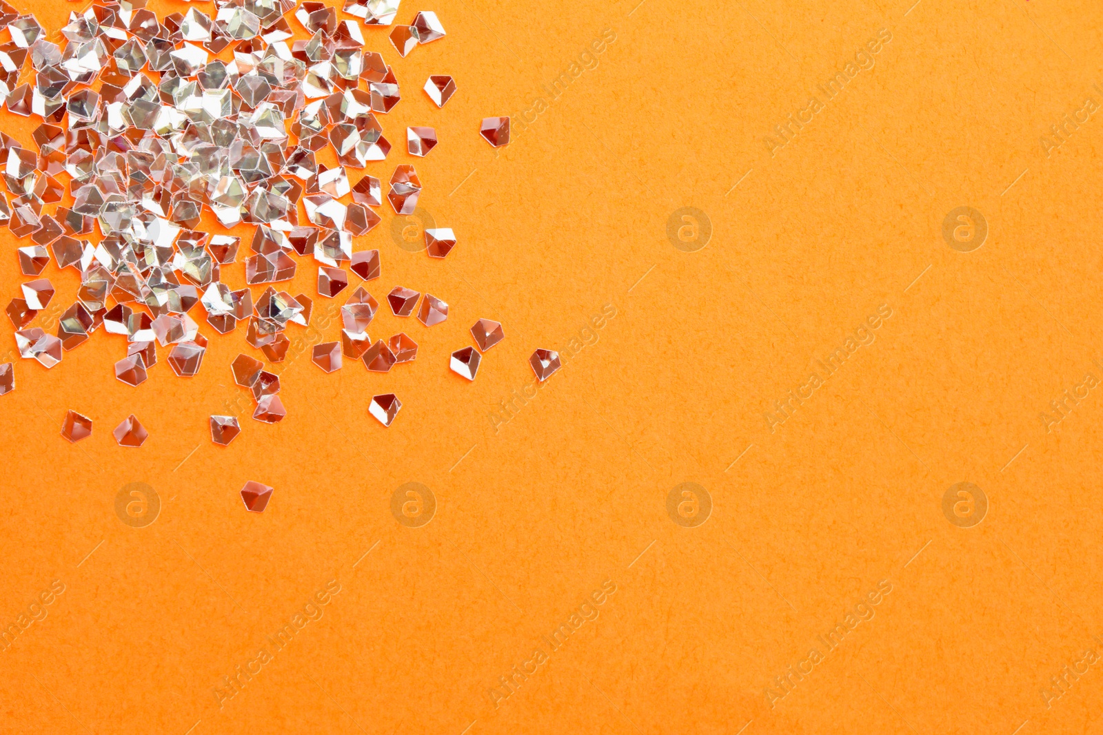 Photo of Pile of shiny glitter on pale pink background, flat lay. Space for text