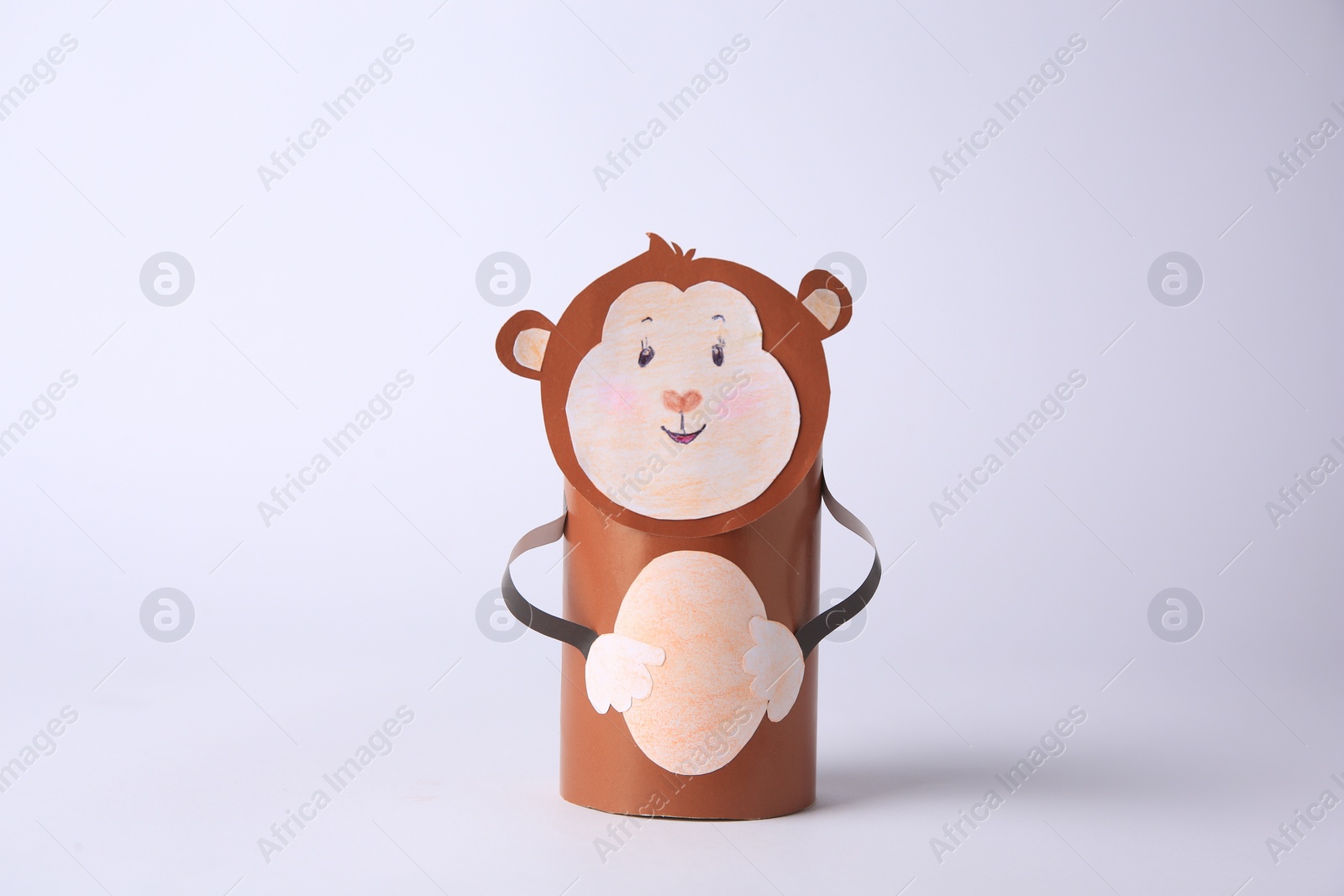 Photo of Toy monkey made from toilet paper hub on white background. Children's handmade ideas