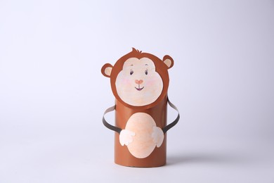 Photo of Toy monkey made from toilet paper hub on white background. Children's handmade ideas