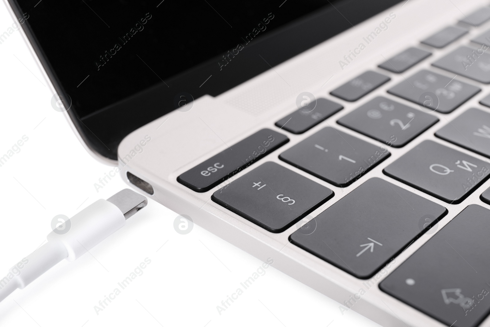 Photo of USB cable with lightning connector and laptop on white background