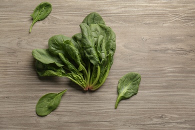 Photo of Fresh green healthy spinach leaves on wooden table, flat lay