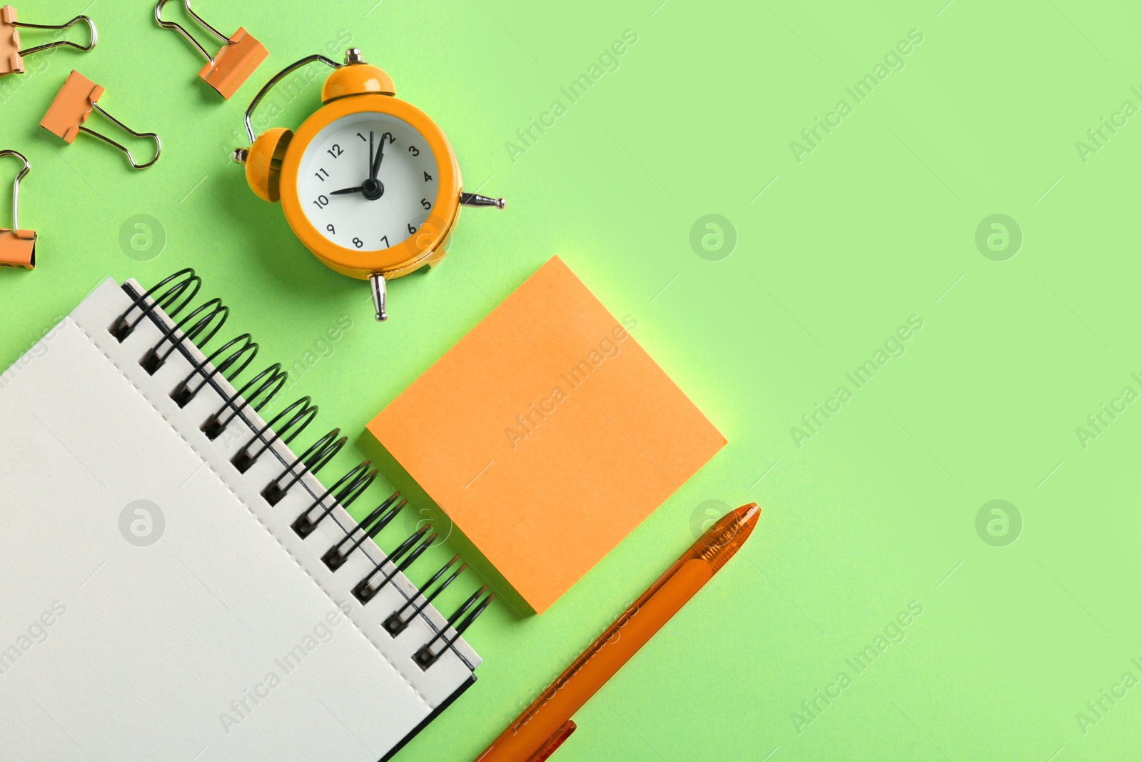 Image of Modern orange office accessories on light green background, flat lay