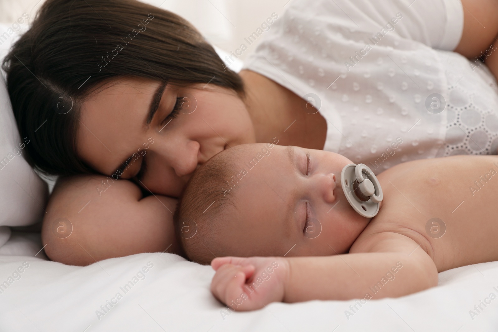 Photo of Mother with her cute baby sleeping in bed