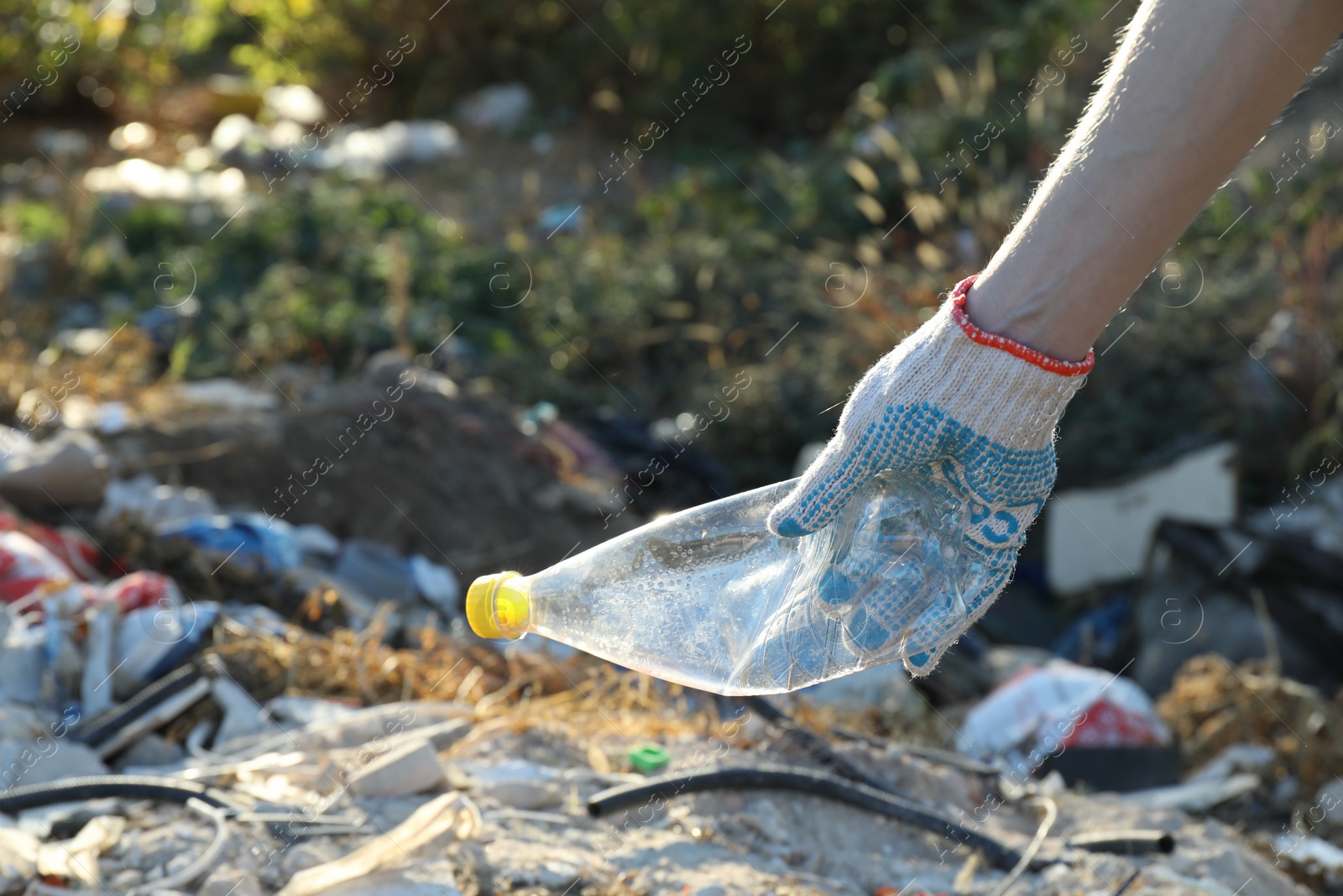 Photo of Woman picking up plastic garbage outdoors, closeup