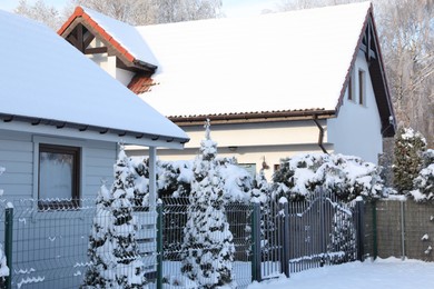 Photo of Houses and trees covered with snow in winter morning