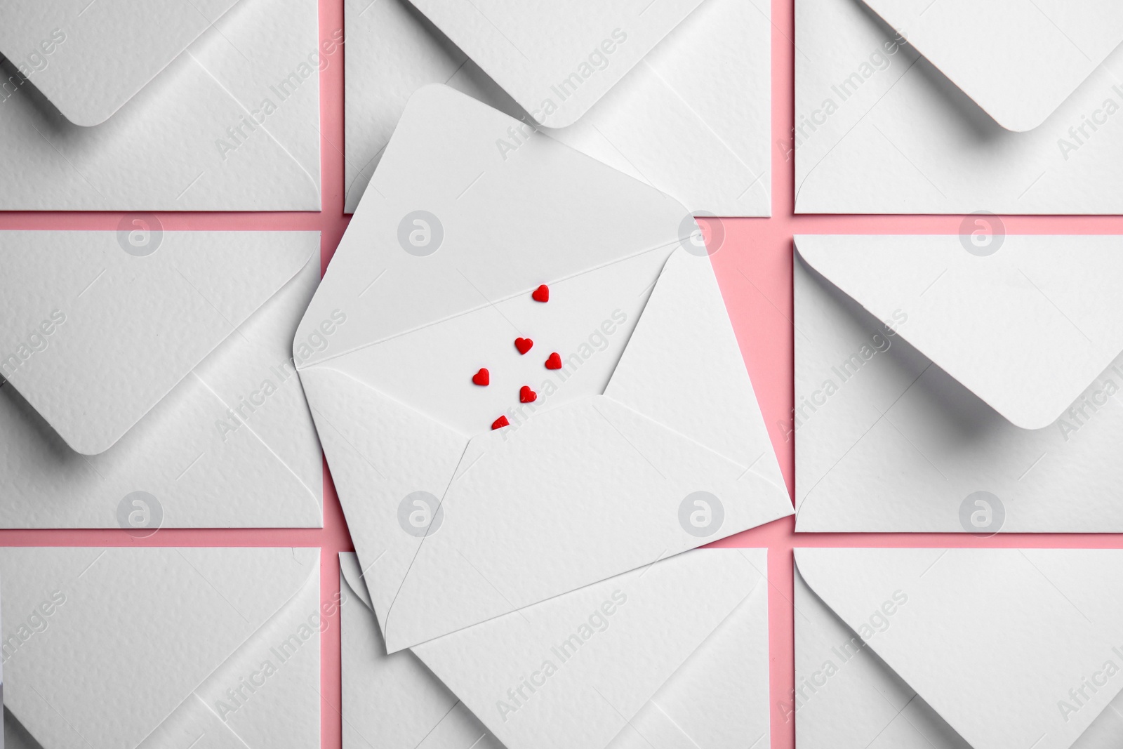 Photo of Envelopes and heart shaped sprinkles on pink background, flat lay. Love letters