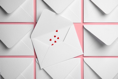 Envelopes and heart shaped sprinkles on pink background, flat lay. Love letters