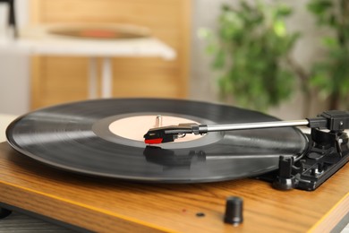 Photo of Turntable with vinyl record on blurred background, closeup. Space for text