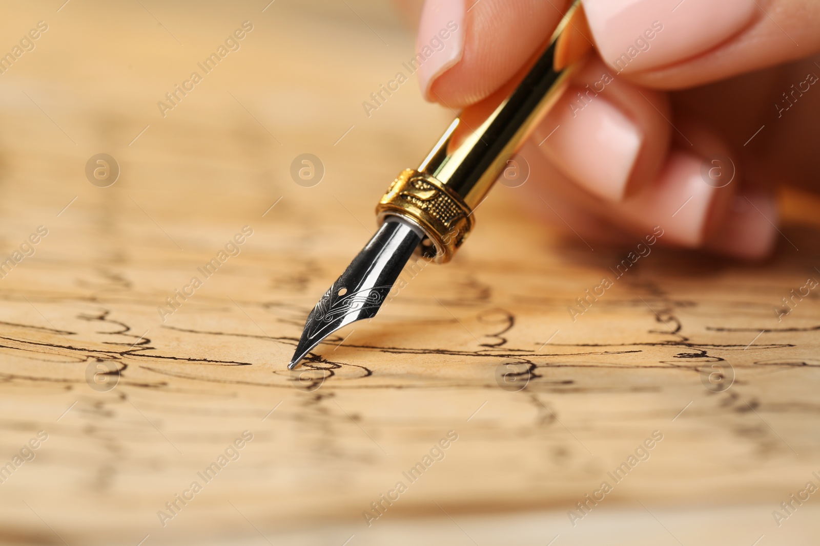 Photo of Woman writing letter with fountain pen, closeup