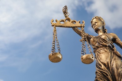 Photo of Symbol of fair treatment under law. Figure of Lady Justice against sky, low angle view with space for text
