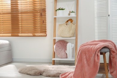 Stylish room interior with wooden ladder near white wall