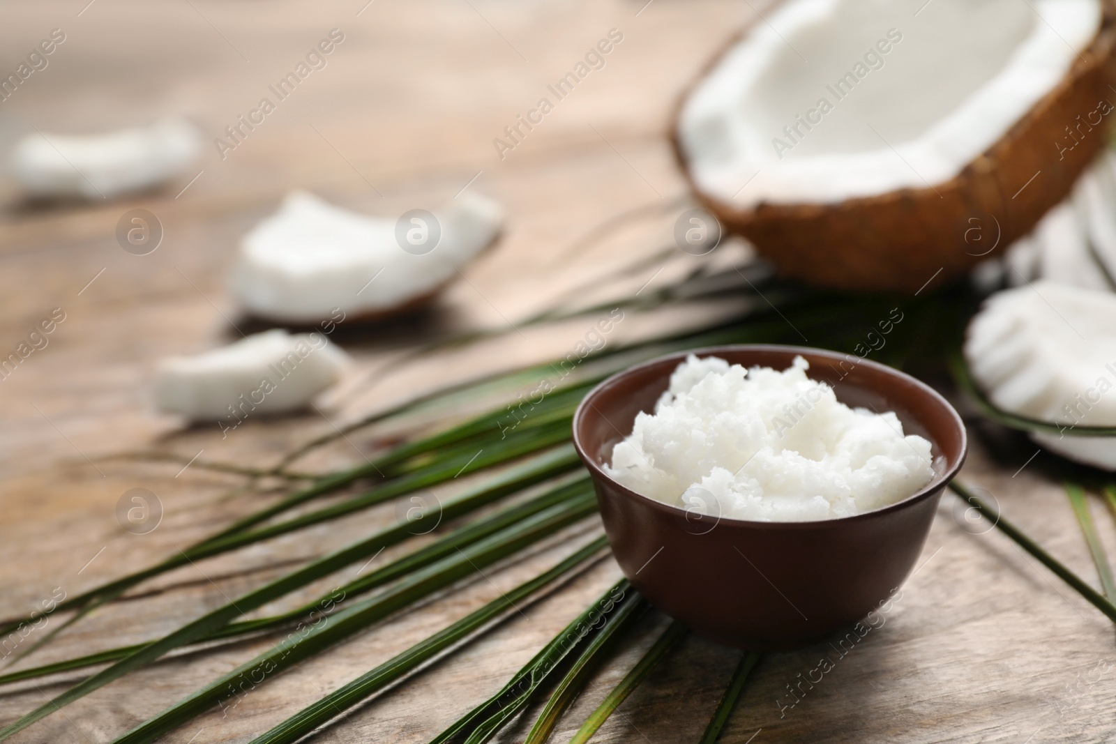 Photo of Bowl with fresh coconut oil on wooden table. Healthy cooking