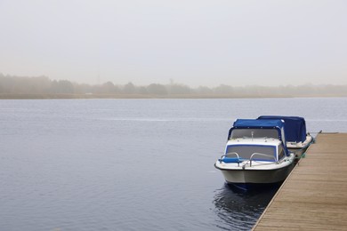 Photo of Picturesque view of wooden pier with moored boat