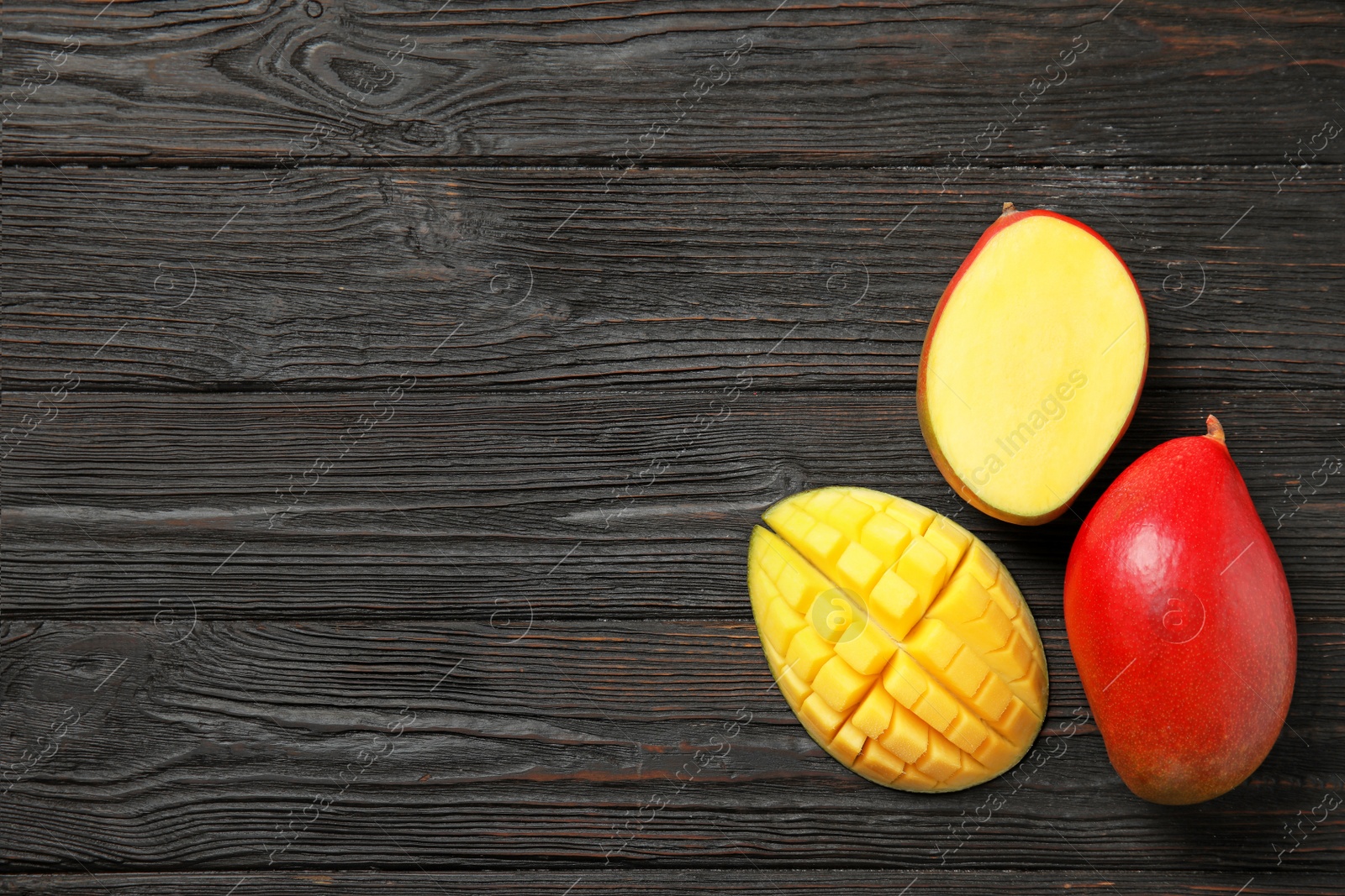 Photo of Flat lay composition with ripe mangoes and space for text on wooden background