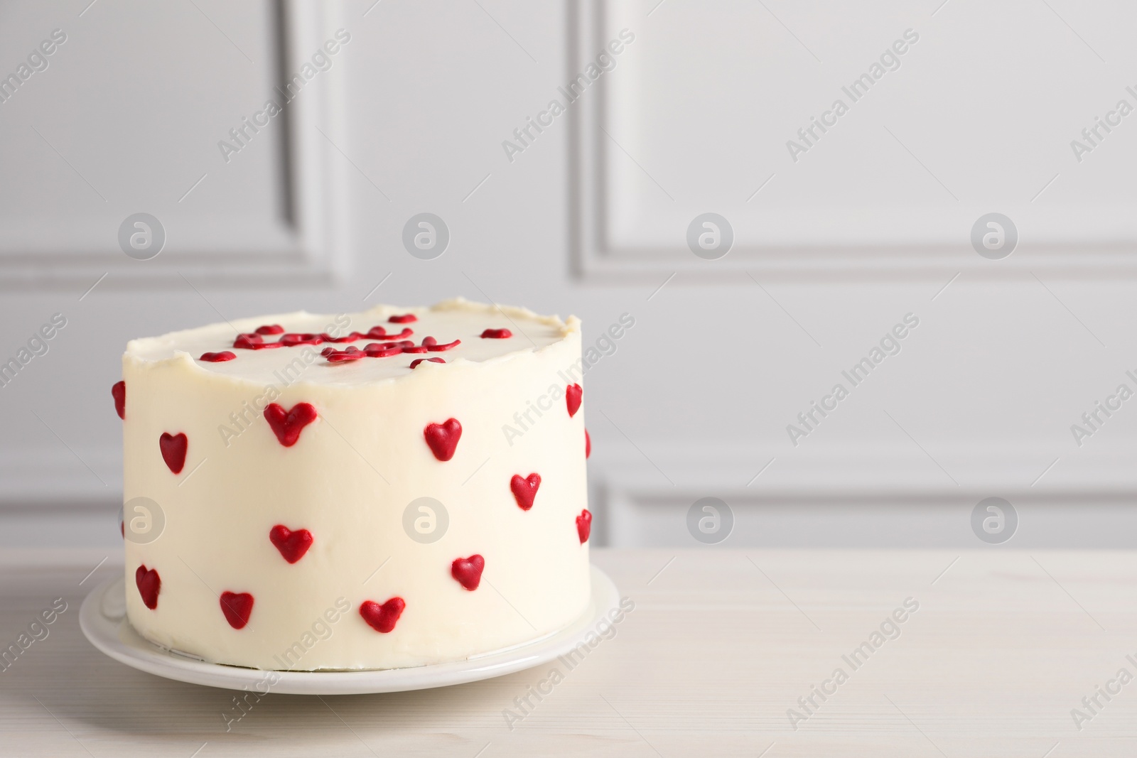 Photo of Bento cake with red hearts on white wooden table, space for text. St. Valentine's day surprise