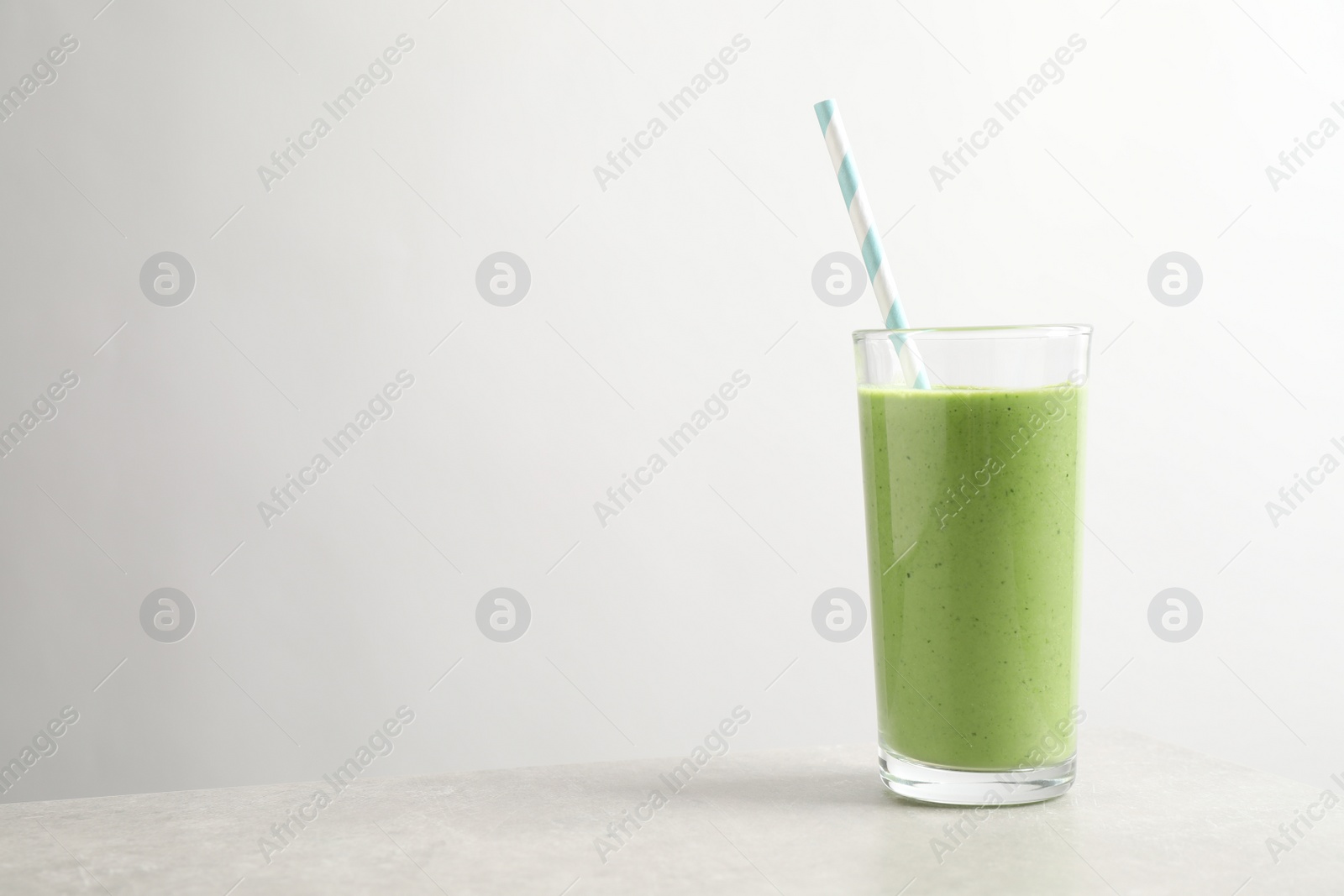 Photo of Tasty kale smoothie on light grey marble table, space for text