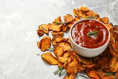 Photo of Sweet potato chips and bowl of sauce on grey background. Space for text
