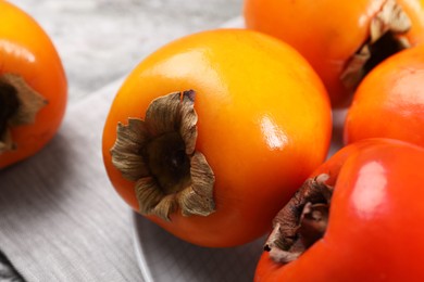 Photo of Delicious ripe persimmons on table, closeup view