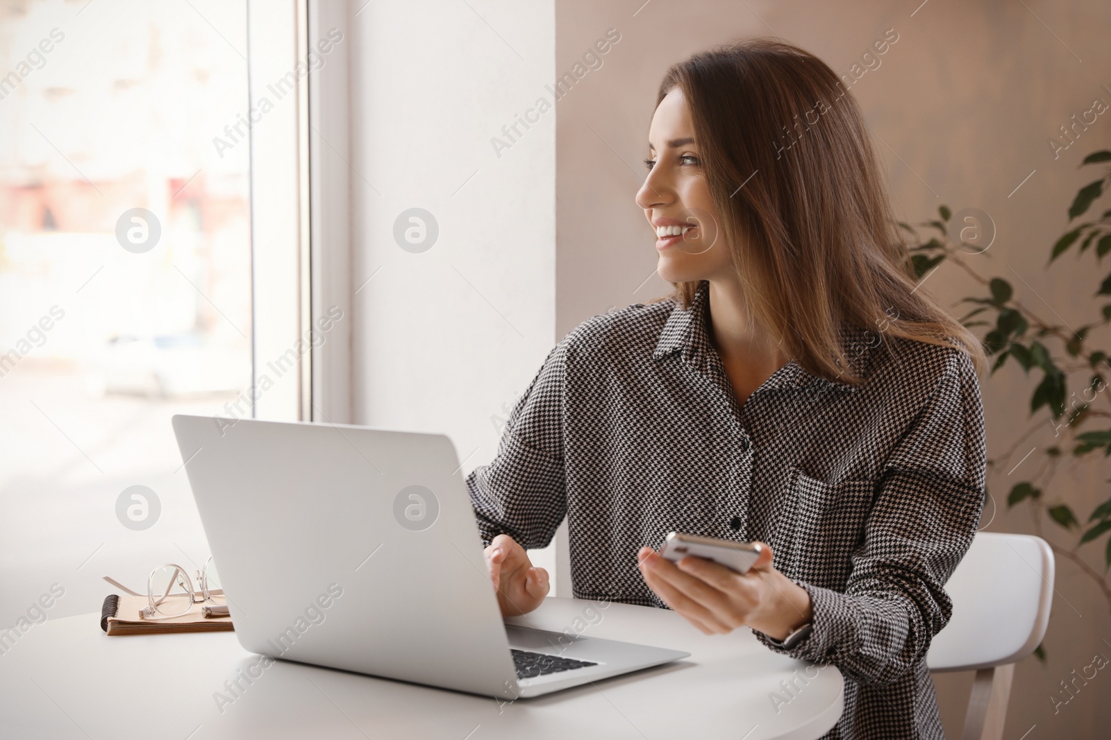 Photo of Young blogger working with laptop at table in cafe