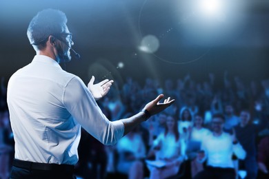 Image of Motivational speaker with headset performing on stage