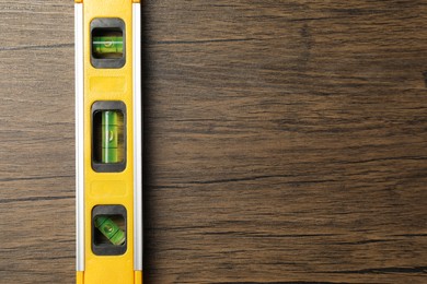 Building level on wooden table, top view. Space for text